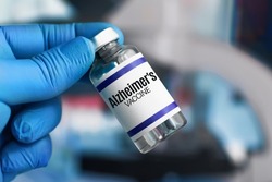 Doctor's hand holding vaccine bottle for Alzheimer's and dementia disesases. Researcher holding Alzheimer's vaccine clinical trial for Alzheimer disease prevention of elderly patient