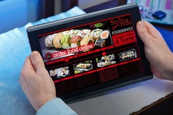 man searching website internet restaurant to purchase food online with tablet in you home / hands of a man in a website of a restaurant food delivery service in the tablet