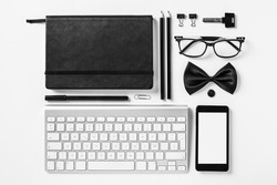 Overhead of essentials office objects in black and white./ Closeup of business objects in order on white desk. 