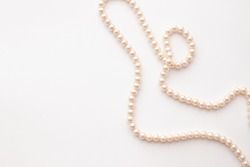 Pearls on white background with copy space. Necklace jewelry.
