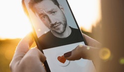 Dating app in mobile phone screen. Woman swiping and liking profiles on relationship site or application. Single woman using smartphone to find love, partner and boyfriend. Mockup website.