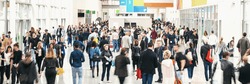 large crowd of anonymous blurred people at a trade fair
