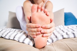 Woman's leg hurts, pain in the foot, massage of female feet at home