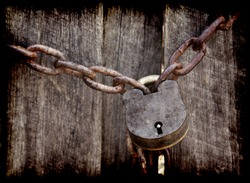old lock and chain around wooden fence