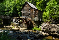 This is the Glade Creek Grist Mill located in Babcock State Park in West Virginia. This area is heavily forested with the Glade Creek running under the  bridge past the mill.