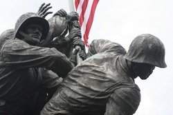 The United States Marine Corps War Memorial in a close-up of the Marines raising the American Flag.  Stark, with the flag lending color to the scene.