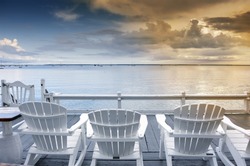 beach chairs overlooking tranquil ocean at sunset on old cape cod