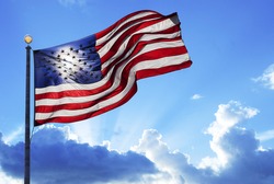 American flag fluttering in the wind under a cloudy sky