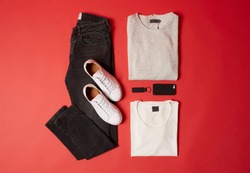 Men Casual Spring Summer Black and White Outfits Black Denim Jeans, White Shoes, White T-Shirt and Black Accessories Top View on Red Background