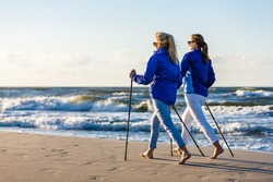 Nordic walking - two women working out on beach
