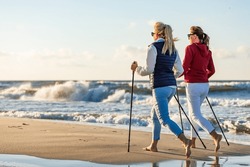 Nordic walking - two women training on beach 