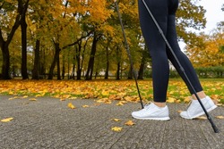 Nordic walking - mid-adult woman exercising in city park 