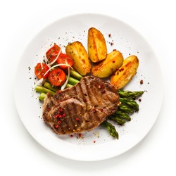 Grilled beef steaks,chips and asparagus on white background 