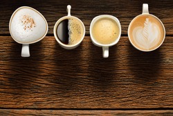 Variety of cups of coffee on old wooden table