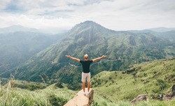 Traveler man enjoy mountains landscape. Travel concept vacations hiking in mountains on Little Adam's Peak, Sri Lanka.