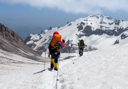 Mountaineers rope descending Kazbek 5054m mountain with backpacks after successful summit ascending, Caucasus, Georgia