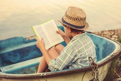 Reading boy in old boat