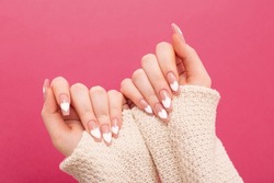 female hands with beautiful long nails with  manicure with  heart pattern in winter clothes