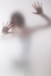woman standing behind blurry glass/behind the window