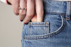 Tiny front pocket on denim pants, close up.	