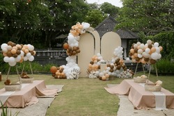 Creative gender neutral baby shower or birthday decoration in the garden. Bohemian style outdoor event set up with balloons. 