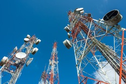 three big radio mast with many dishes in blue sky and few cloud