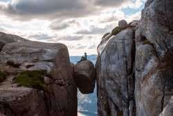 Woman on Kjeragbolten Travel in Norway Kjerag mountains, extreme vacations, adventure, tourist, happy emotions, success concept