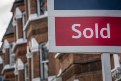 Property 'Sold' sign on urban UK street