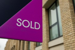 Estate Agent  'Sold' sign on urban UK street