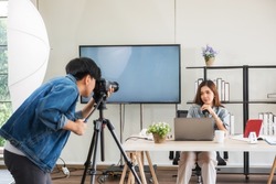 Behind the scene concept. Videographer prepare to record footage before streaming live online of young Asian woman blogger with studio lighting. broadcasting vlogger, internet influencer.