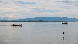 Fishermen sailing long tail boats with flying bird at sea in Kung Krabaen Wildlife Reserve, Chanthaburi, Thailand.