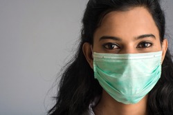 Closeup portrait of a young girl or woman doctor wearing a medical or surgical mask