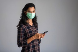 Woman with a surgical mask using a smartphone for communication. work from home concept.