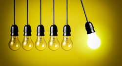 Idea concept on yellow background. Perpetual motion with light bulbs