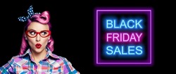 Black Friday Sales, discounts, rebates, trade deals concept - excited surprised pin up woman in red glasses looking sideways. Purple hair girl in pinup rockabilly style. Neon light sign. Wide image.