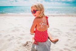 sun protection- happy little girl with suncream at beach
