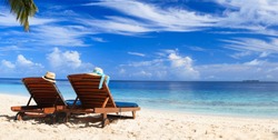 Two beach chairs on the tropical sand beach
