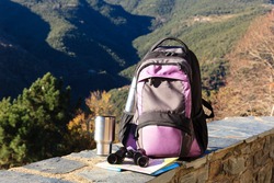 backpack, binoculars, map in mountains, travel