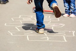 kids playing hopscotch on playground outdoors