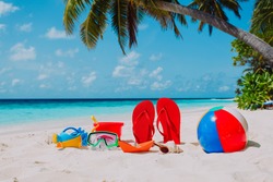 Colored slippers, toys and diving mask at beach