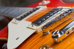 closeup of a guitar bridge with control knobs