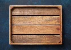 Empty wooden box on blue background. View from above. Copy space