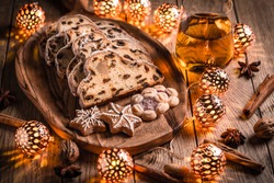 Christmas Stollen and cookies with apple mulled wine and Christmas lights. Traditional Sweet Fruit Loaf with icing sugar. 