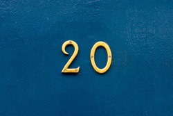 House number 20 in thin bronze metal numbers - the twenty is on a blue wooden front door