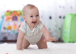crawling funny baby boy in nursery at home