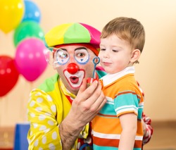 joyful kid with clown on birthday party