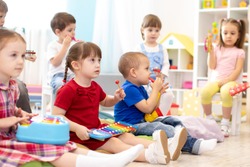 Music lesson for group of children in kindergarten or kids centre