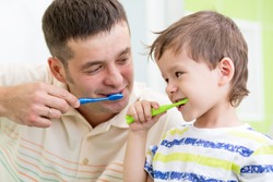 father and kid son brushing teeth in bathroom