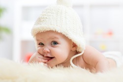 Cute little baby girl looking into the camera and weared in white hat. 