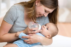 Mother gives to drink water baby from bottle